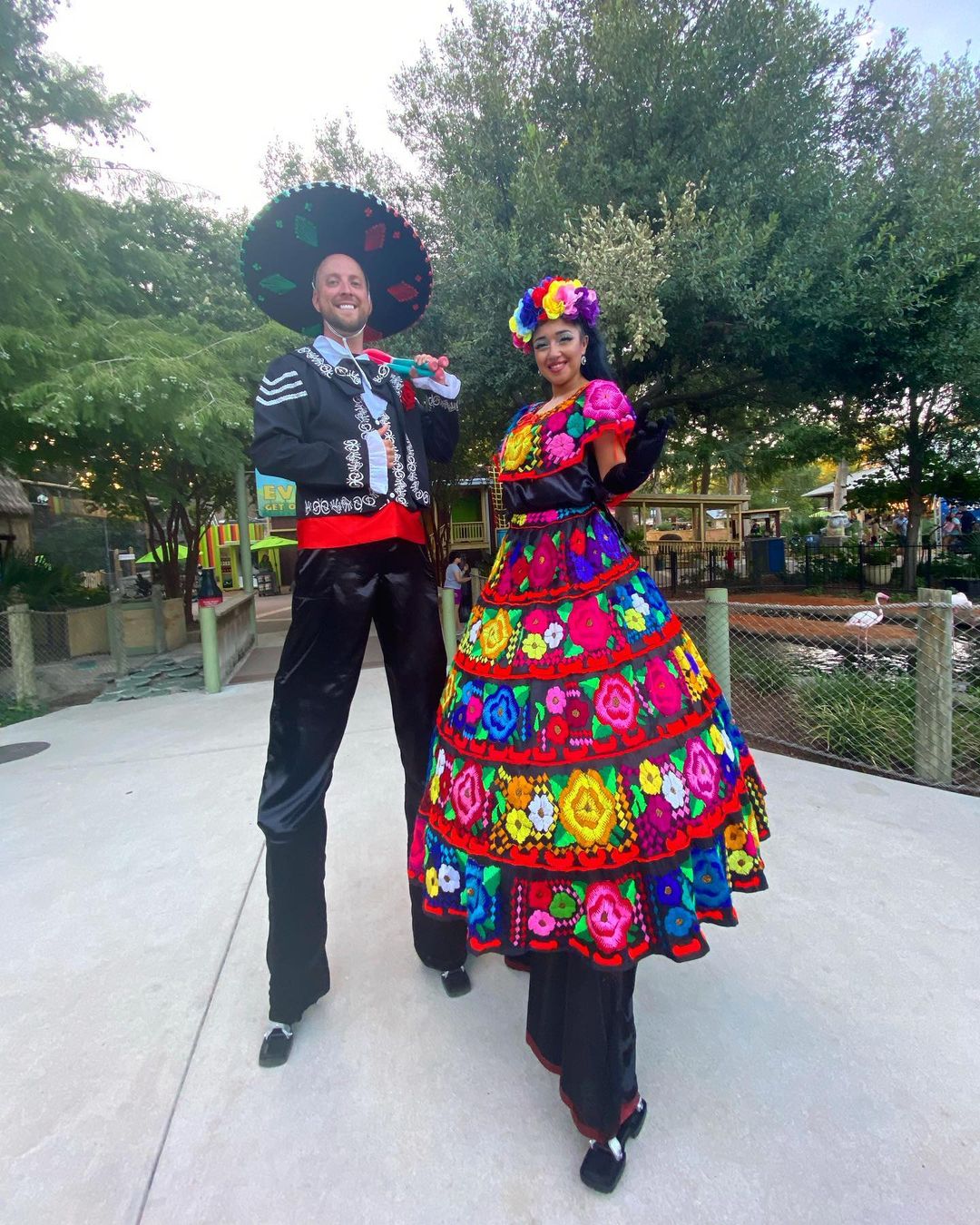 Two stilt-walkers in dia de los muertos garb