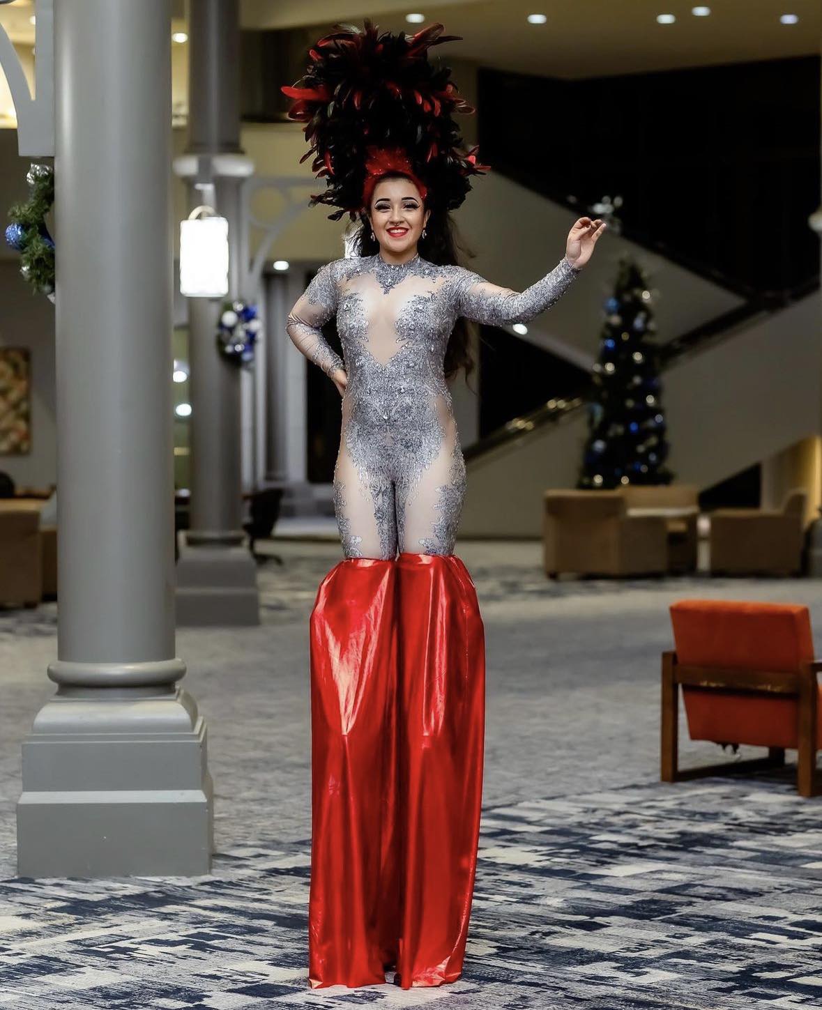 Woman in silver bodysuit and red stilts